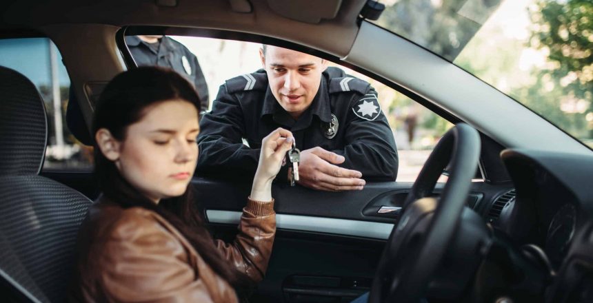 Male police officers in uniform check female driver on the road. Law protection, car traffic inspector, safety control job
